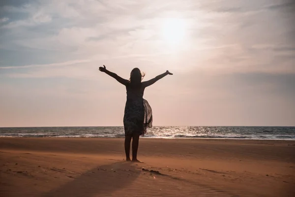 Özgürlük silueti ve sahildeki mutlu kız — Stok fotoğraf