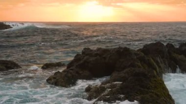 Okyanus dalgaları gün batımında kayalara çarpar Playa Benijo plajı, Tenerife, Kanarya