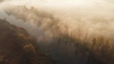 Güneşin sisli nehrin üzerinde doğuşunun hava aracı görüntüsü