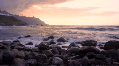 Okyanus dalgaları gün batımında kayalara çarpar Playa Benijo plajı, Tenerife, Kanarya