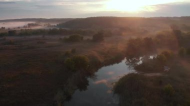 Güneşin sisli nehrin üzerinde doğuşunun hava aracı görüntüsü