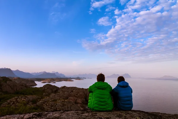 Rear view of two friends sitting together on clief near ocean — Stock Photo, Image