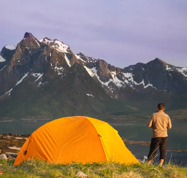 Туристическая палатка и спортивный человек на берегу озера — стоковое фото