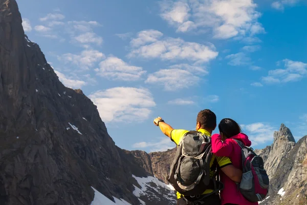 Giovane coppia turistica in piedi su pietra vicino lago di montagna — Foto Stock