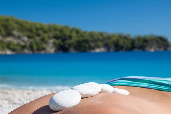 Beautiful woman getting hot stones treatment out in the nature. — Stock Photo, Image