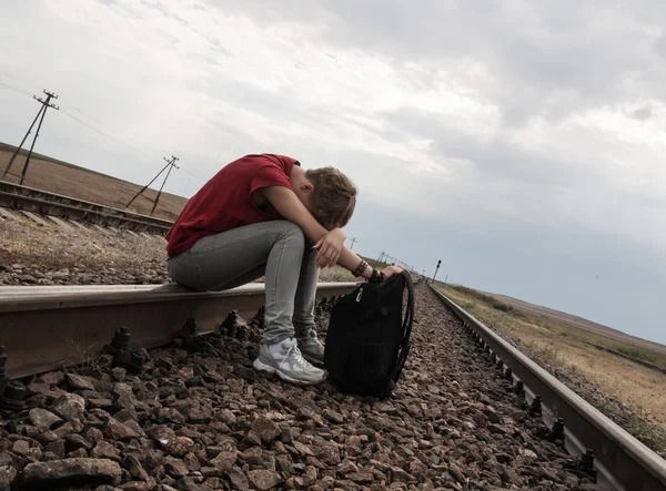 Teen girl with problems sitting on rail road — Stock Photo, Image