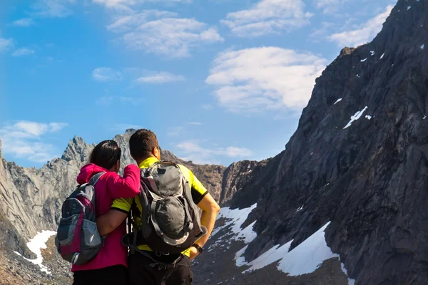 Young tourist couple standing  on stone near mountain lake — Stock Photo, Image