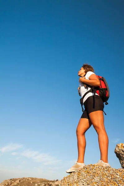 Mujer excursionista se para en roca de montaña — Foto de Stock