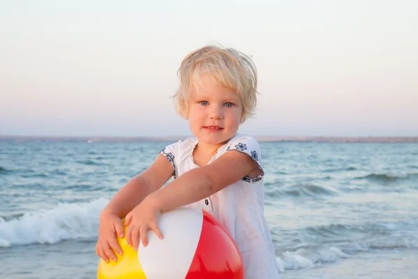 Adorable toddler girl playing with ball on sand beach — Stock Photo, Image