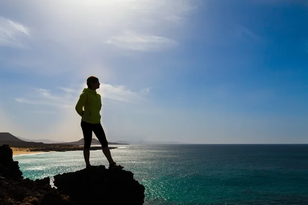 Silhouette di donna escursionistica vicino al mare — Foto Stock