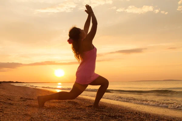 Giovane ragazza la spiaggia all'alba facendo esercizio di yoga — Foto Stock