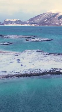 Norveç, Troms 'daki Sommaroy adalarının kışın nefes kesici güzelliğini tecrübe edin. Sakin plajları, buzlu suları, karlı dağları ve balıkçı köyünü keşfedin..