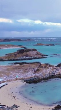 Norveç, Troms 'daki Sommaroy adalarının kışın nefes kesici güzelliğini tecrübe edin. Sakin plajları, buzlu suları, karlı dağları ve balıkçı köyünü keşfedin..