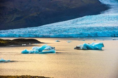 Fjallsarlon buzul gölleri sakin sularda yüzen buzdağlarını sergiliyor. Büyük buzul zeminine vuran alacakaranlık ışığını yansıtıyor. İzlanda 'da ikonik bir konum