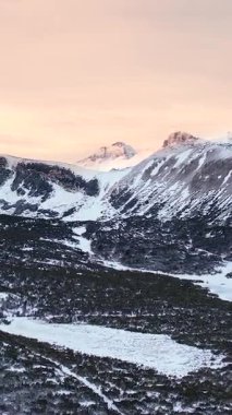 Alplerdeki karlı dağ manzarasının hava aracı görüntüleri. Dramatik bulutlu hava ve kayalık dağlar