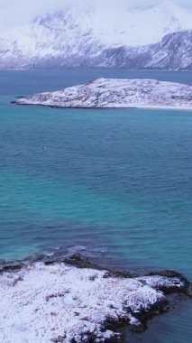 Norveç, Troms 'daki Sommaroy adalarının kışın nefes kesici güzelliğini tecrübe edin. Sakin plajları, buzlu suları, karlı dağları ve balıkçı köyünü keşfedin..