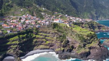 Portekiz 'deki Seixal Madeira Adaları' nın hava manzarası. Adayı kaplayan geniş bir bitki örtüsü tabakası. Dik bir okyanus kıyısındaki tatil köyü