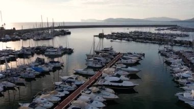 Alghero, Sardinya 'daki marinanın çarpıcı hava manzarasının tadını çıkarın. Tarihi mimari arkaplan ve güzel sahil şeridine karşı tekneler ve yatlar yer alıyor..