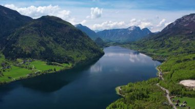 Avusturya 'daki Grundlsee Gölü' nün nefes kesici hava manzarasını deneyimlemek, sakin suları, yeşil manzaraları ve güneşli bir günde görkemli dağları vurgulamak.