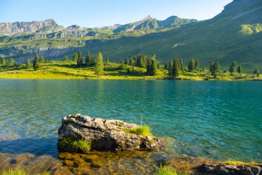 İsviçre 'deki Engstlensee Gölü' nün güzelliğini keşfedin. Berrak sular çevresindeki dağları ve yeşillikleri yansıtıyor ve sakin bir doğal manzara sergiliyor. Seyahat hedefi ve popüler patika.