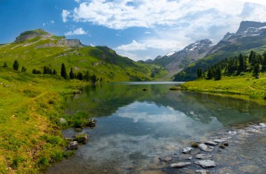 İsviçre 'deki Engstlensee Gölü' nün güzelliğini keşfedin. Berrak sular çevresindeki dağları ve yeşillikleri yansıtıyor ve sakin bir doğal manzara sergiliyor. Seyahat hedefi ve popüler patika.