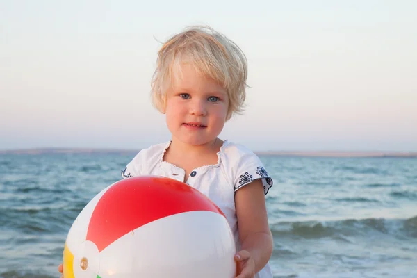 Adorable toddler girl playing ball on sand beach — Stock Photo, Image