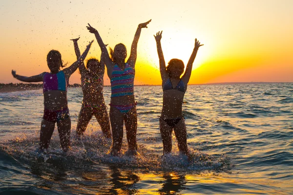 Mutlu genç kız plajda atlama grubu — Stok fotoğraf