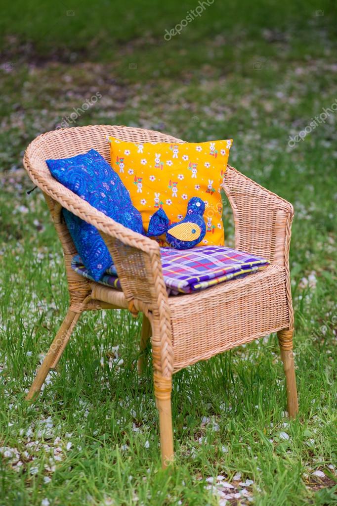 Wicker chair with cushions and a plaid close-up on background of