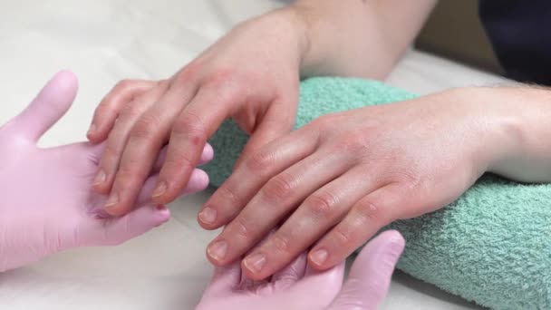 在美容师的预约上手照顾 涂上润肤霜 用棍子包裹双手 美容师把液体涂在手上 手举得很近断了的手 — 图库视频影像