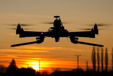 Hexacopter drone flying in the sunset clipart