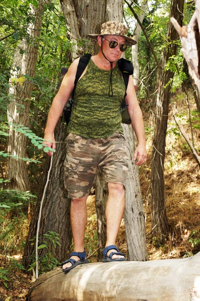 バックパックを持った男が倒木の谷を横切り — ストック写真