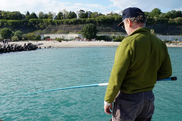 Fiskare Med Ett Fiskespö Står Piren Och Fångar Fisk — Stockfoto