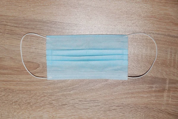 Hafif tahta arka planda tıbbi koruyucu maske