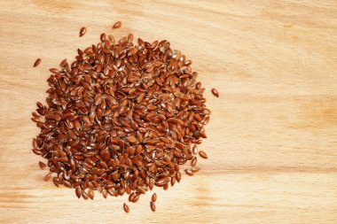 Hafif ahşap arka planda keten tohumları.