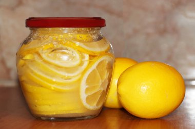 Bir kavanoz şeker limon ve iki taze limon..