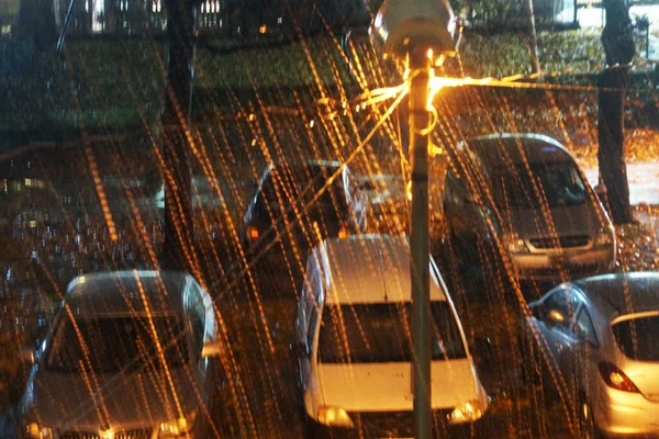 道路灯の光に照らされた雨の中駐車場の車上からの眺め — ストック写真