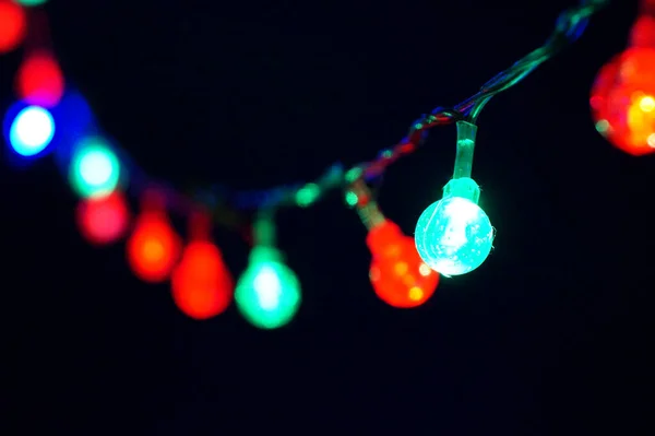 Koyu renkli Noel çelenginde parlıyor. Yaklaş, seçici odaklan.