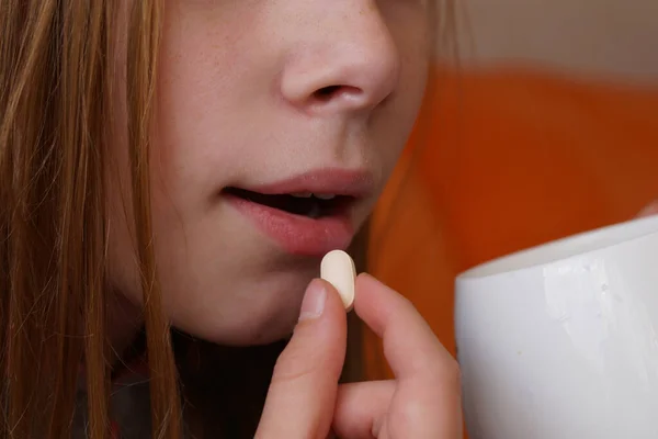 a girl takes a pill close up