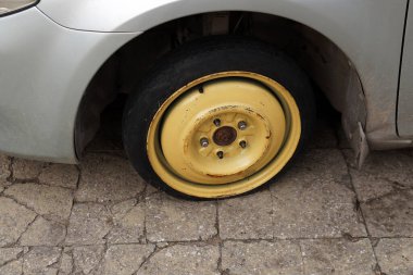 Lastiği patlamış eski bir araba tekerleği. Yaklaş..