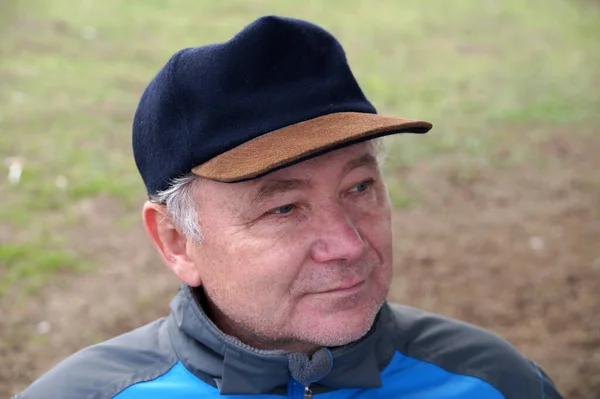 一个戴着自然背景帽子的笑容满面的中年男人的画像 — 图库照片
