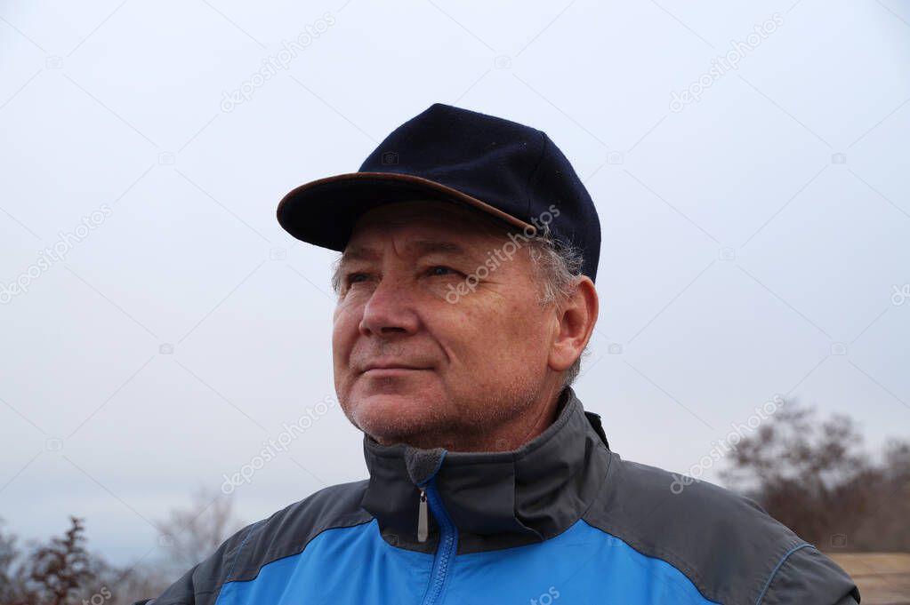 portrait of a middle aged man wearing a cap.