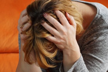 Kadın, ağrıyan kafasını elleriyle sıktı.