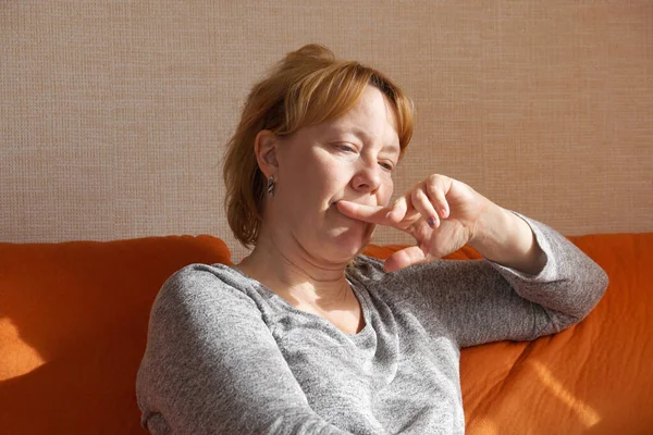 Düşünceli kadın kanepede oturuyor. Yakın çekim..