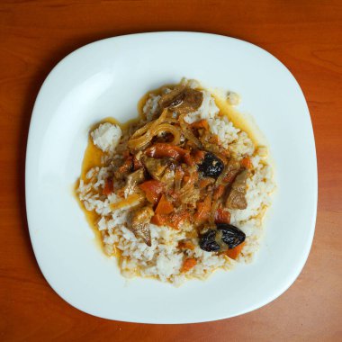 pirinç ve et kebabı, beyaz tabakta sebzeli, yukarıdan manzaralı.