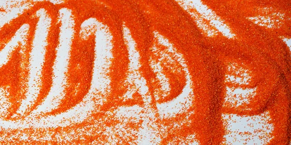 orange artificial sand for sand therapy on a white table close-up