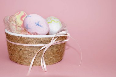Paskalya konsepti, pembe arka planda boyalı yumurtalarla dekoratif kase.