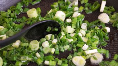 Doğranmış yeşil soğan yakın plan çekimde kızartılmış.