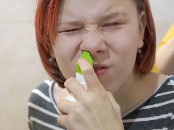 girl washing her nose with medicinal spray close-up