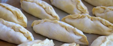 Yiyecek arka planı için fırın tepsisi üzerinde çiğ küçük turtalar.