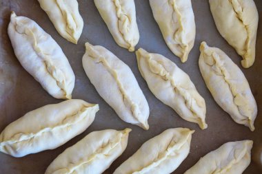 Yemek arkaplanı için fırın tepsisindeki çiğ küçük turtalar, yukarıdan görünüm